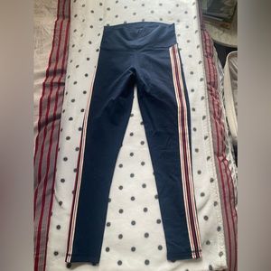 Navy blue TNA leggings with stripes going down the side